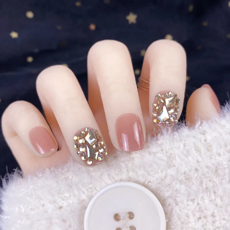 Champagne gold full diamond manicure patches laid out on a surface, showing the sequin finish and adhesive backing