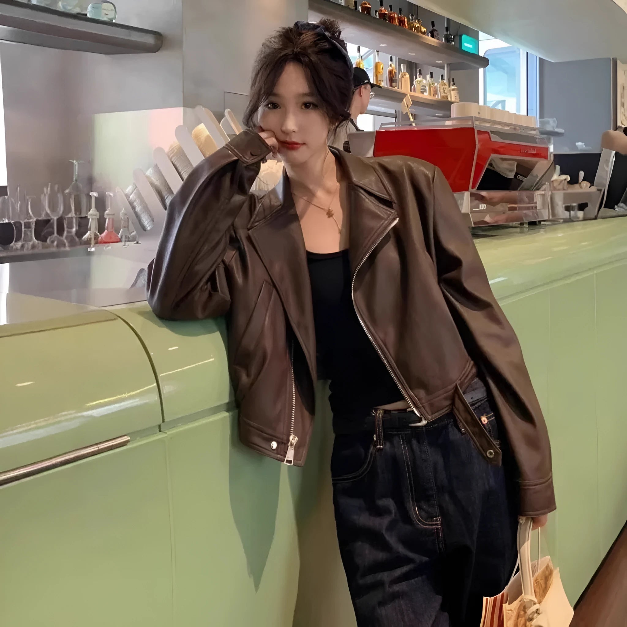 Brown women's retro slim-fit imitation leather jacket with pockets on a model.