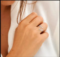Stainless steel ring in steel colour, one-size adjustable band on a plain background