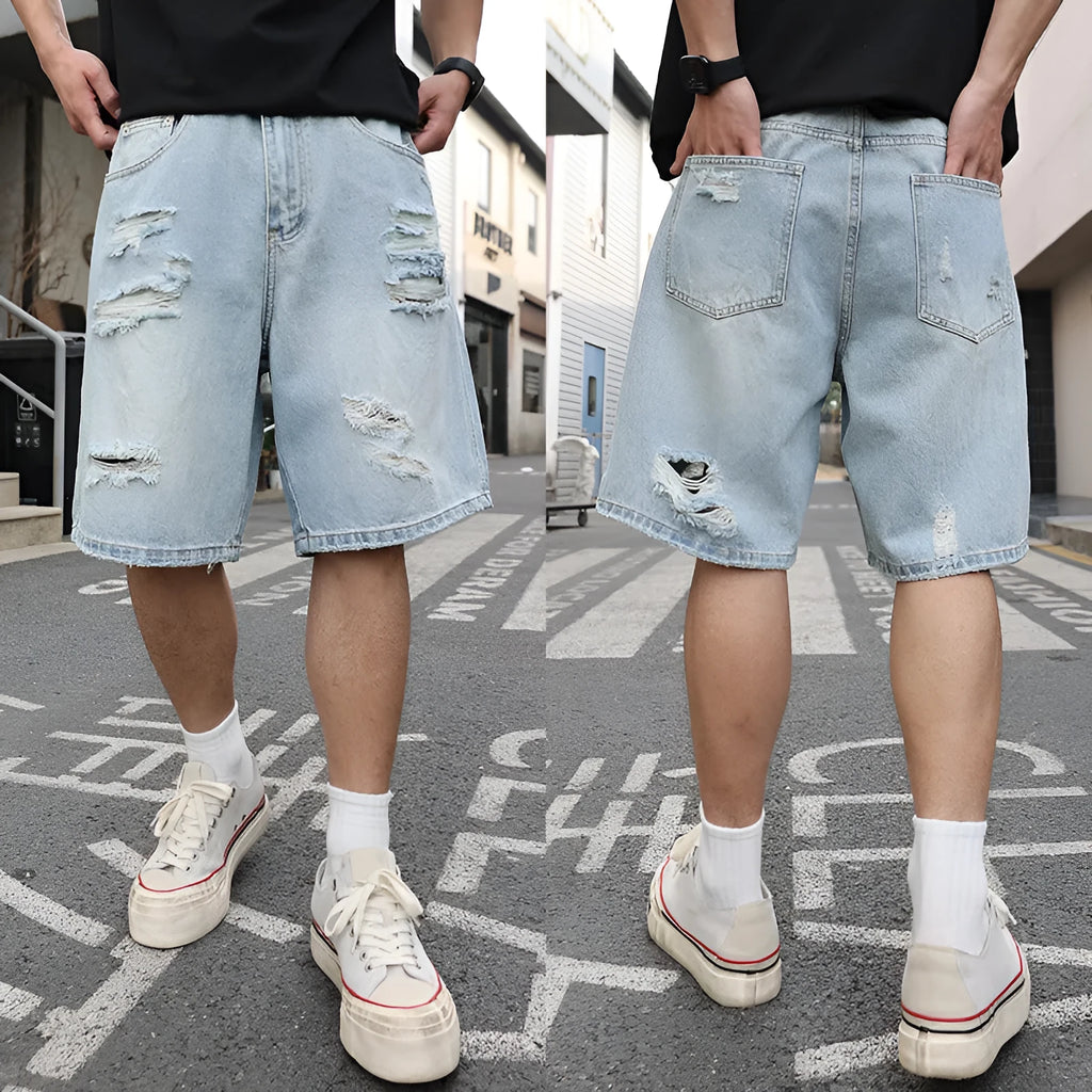 Men's light blue ripped denim shorts with a loose, straight leg fit on a plain background.