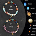 Two natural stone beaded bracelets with metal zodiac charms on a dark background.