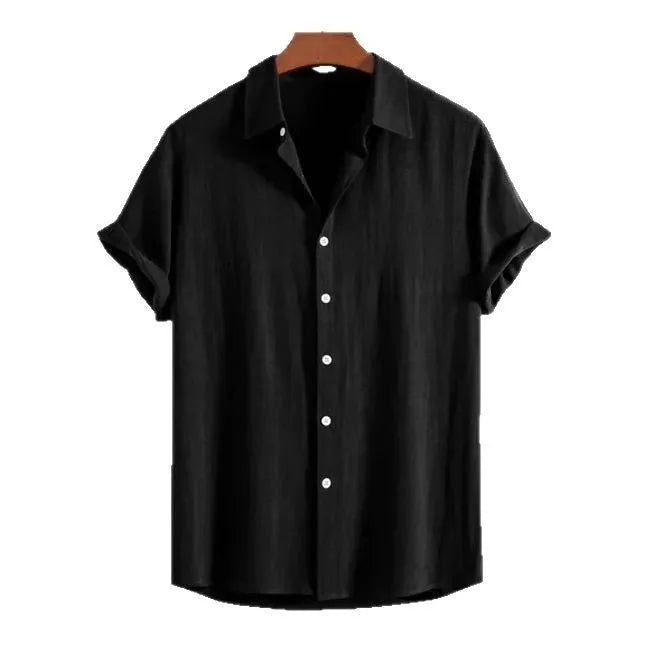 A man wearing a loose-fitting black short-sleeve cotton linen cardigan on a beach.