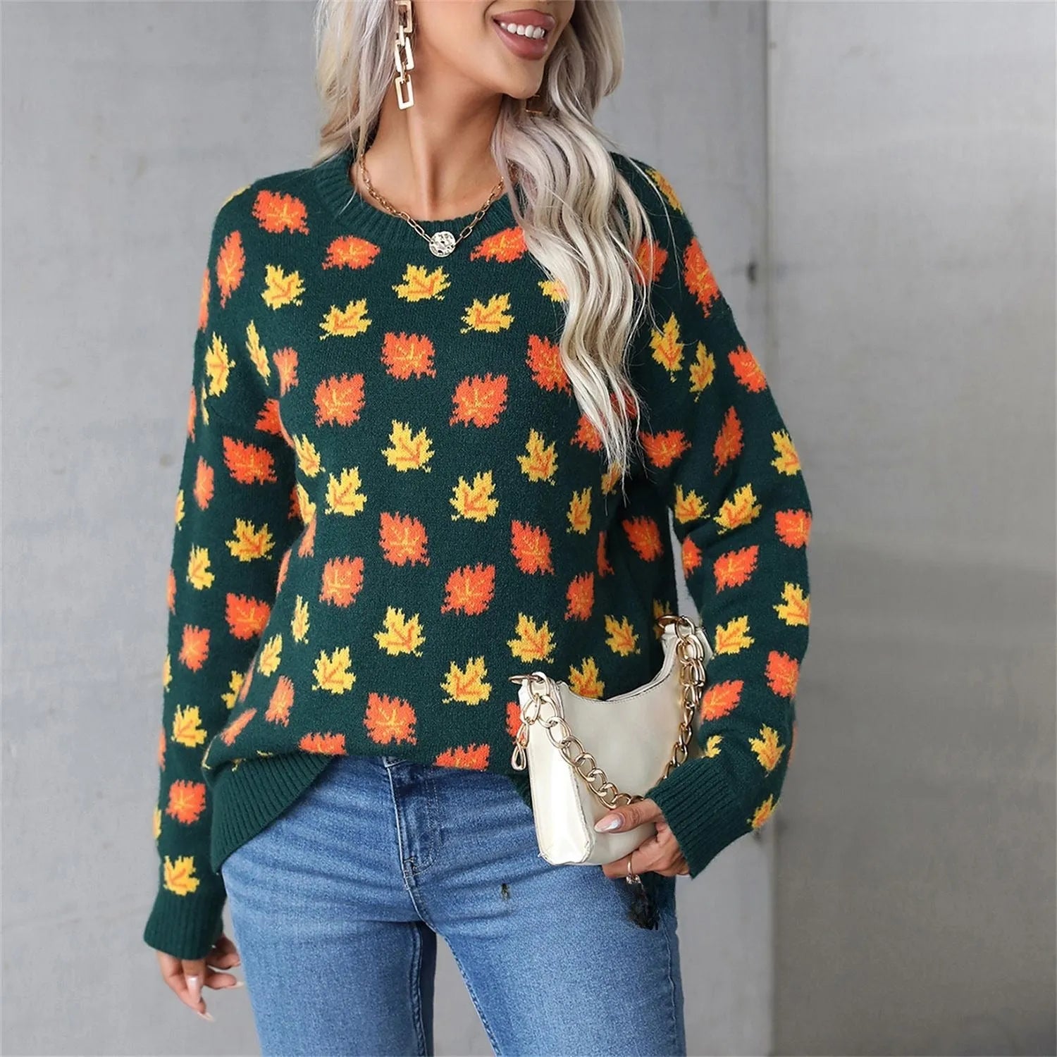Beige and dark green loose fit Christmas sweater with maple leaf design and round neck.