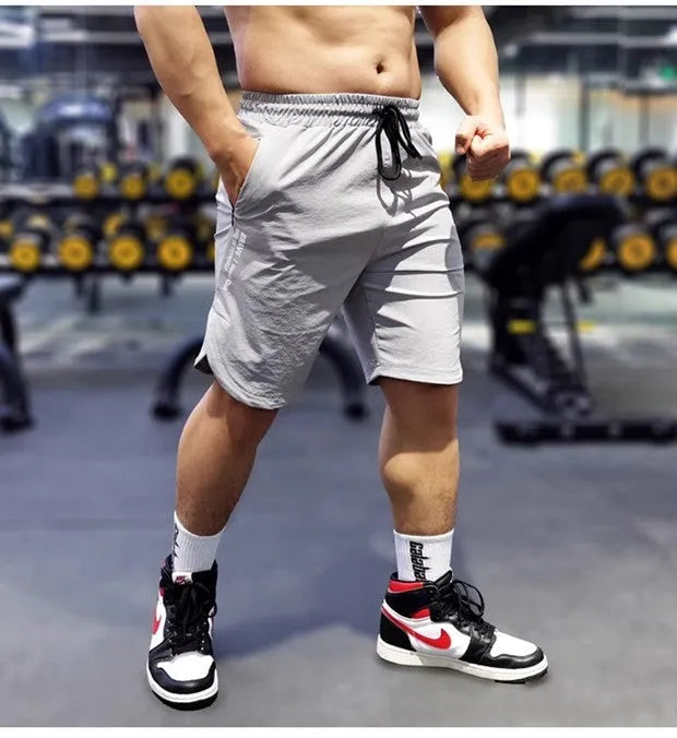 Men's black quick-drying thin running shorts made of nylon and spandex blend on a grey background.