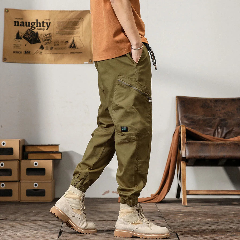 Men's khaki cotton harem pants with ankle bands and a loose, tapered fit.