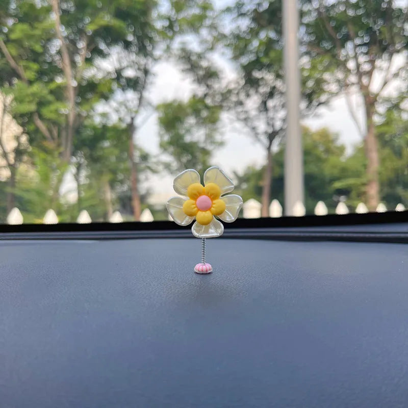 Small blue plastic swing ornament for car dashboard, 5cm tall on a grey surface.