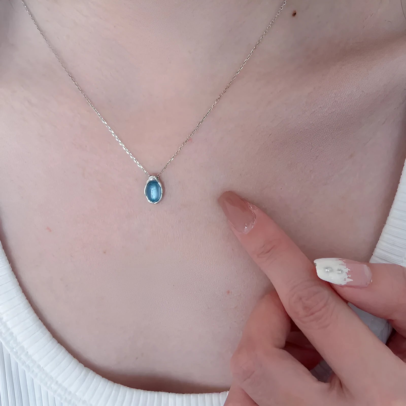 Geometric navy blue water drop pendant necklace on a platinum-colour adjustable cross chain.