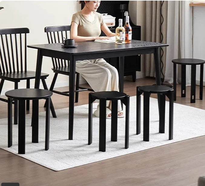 A single modern stackable iron dining stool with a round seat in a cream colour, showing its tubular steel frame.