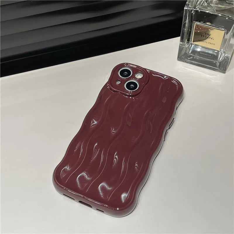 Silicone iPhone 17 case with a textured water ripple surface in green, shown fitted on a phone.