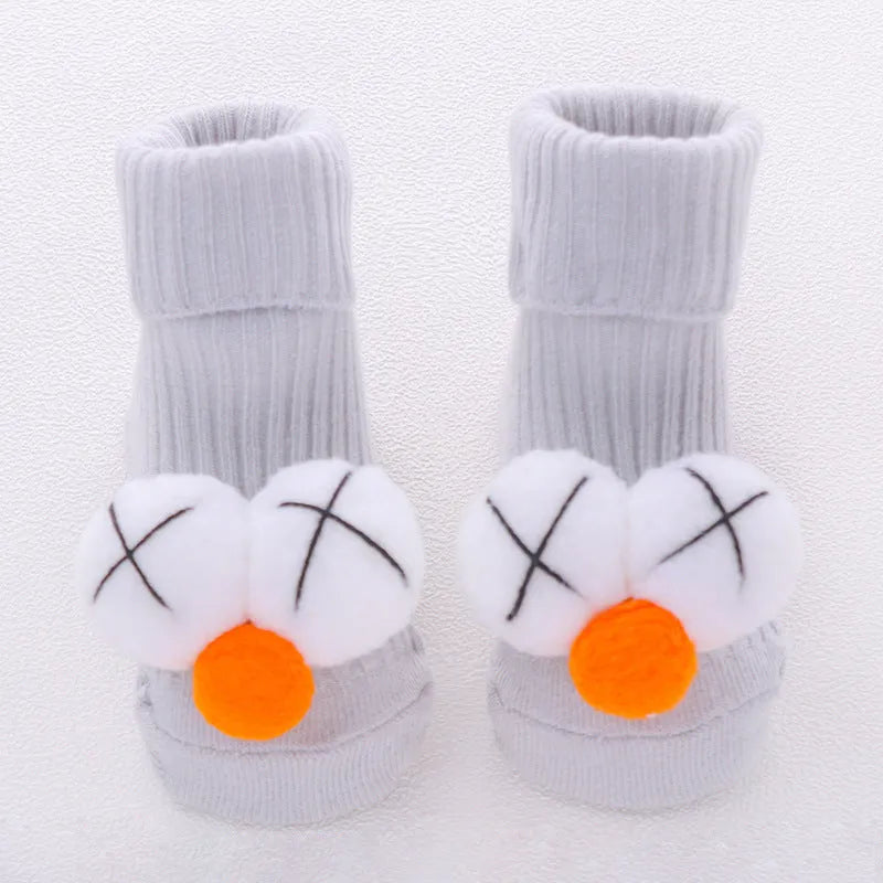 Cotton baby floor socks in various colours and patterns including pink bows, grey stars, and panda design.