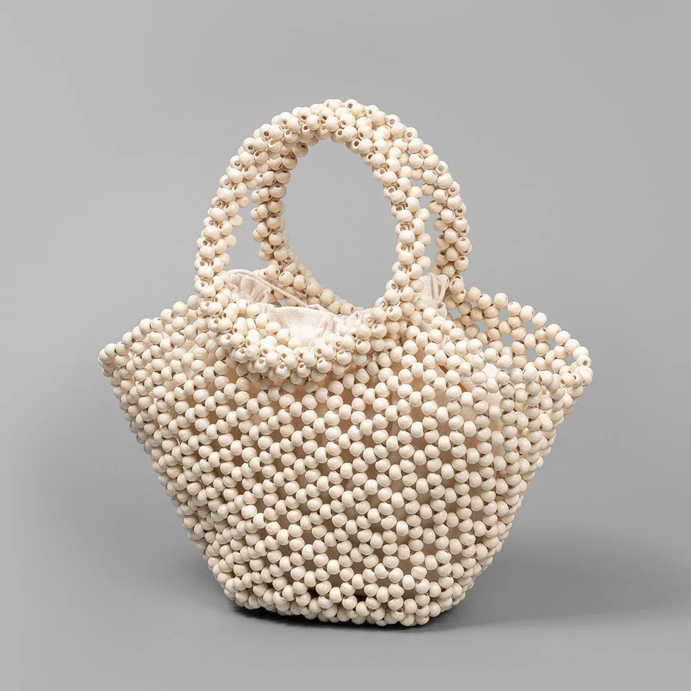 Hand-woven dumpling-shaped maple beach handbag with wooden bead decoration in milky white colour