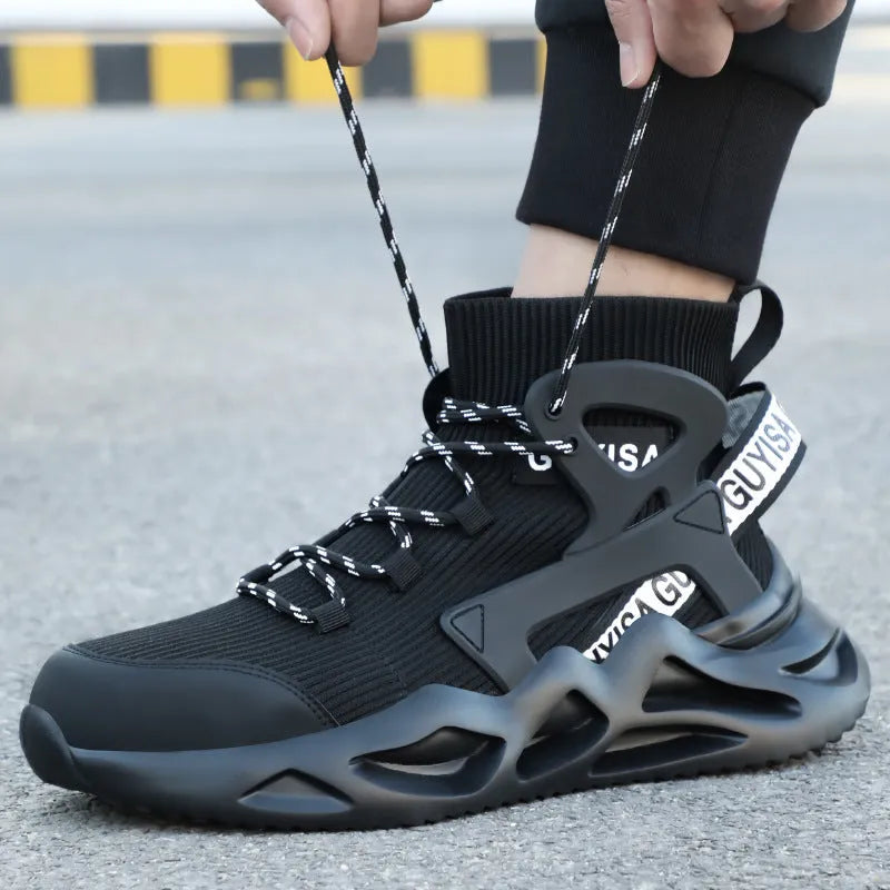 Men's black and white steel toe cap safety work shoes with fly woven mesh upper and rubber sole on concrete floor