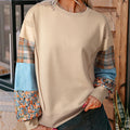 Beige and red women's loose-fit plaid long-sleeved polyester top on a hanger.