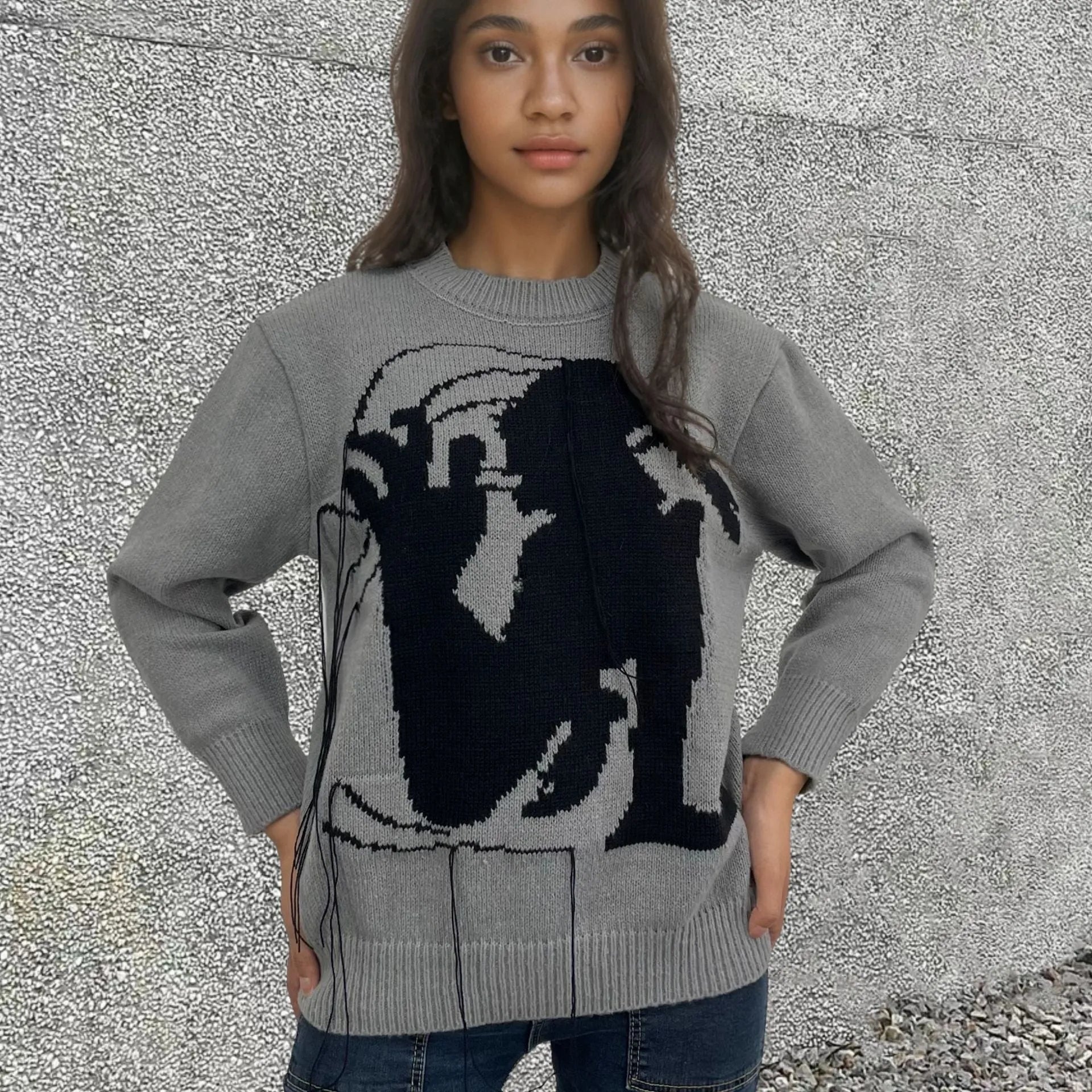 Grey loose women's alpaca wool pullover sweater with tassel detail on a hanger.