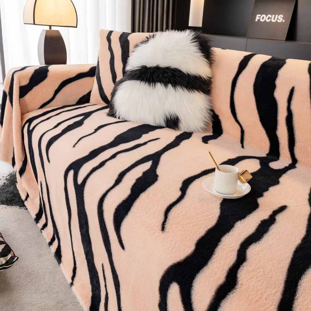 Zebra pattern flannel sofa cover in caramel colour on grey sofa, showing thickened non-slip construction.