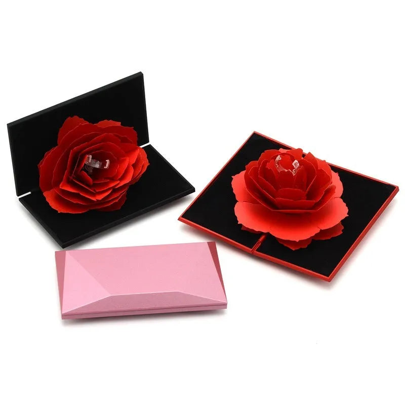 Red rotating 3D heart-shaped plastic ring box with a rose, open to show ring placement.