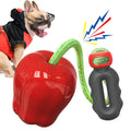 Green plastic apple-shaped dog chew toy with a squeaker on a grass background.