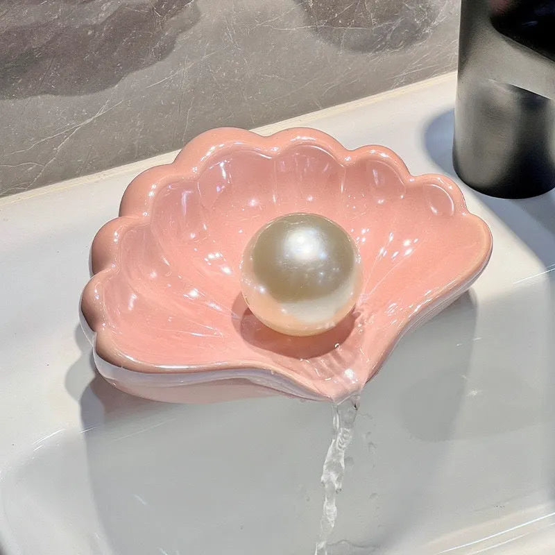 White plastic shell-shaped soap dish on bathroom countertop