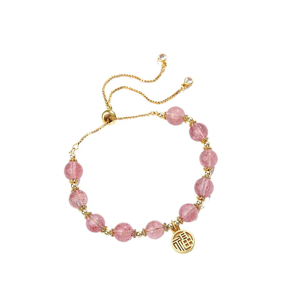 Women's strawberry quartz bracelet with geometric charms and fu character on wrist