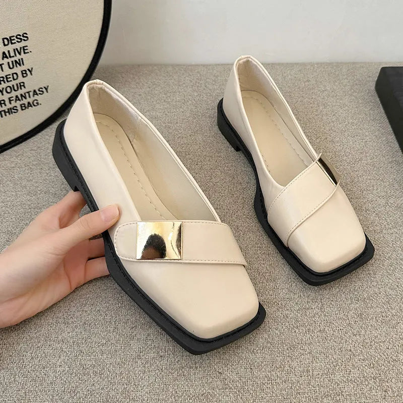 Beige women's square-toe flat shoes with a metal buckle and low rubber sole.