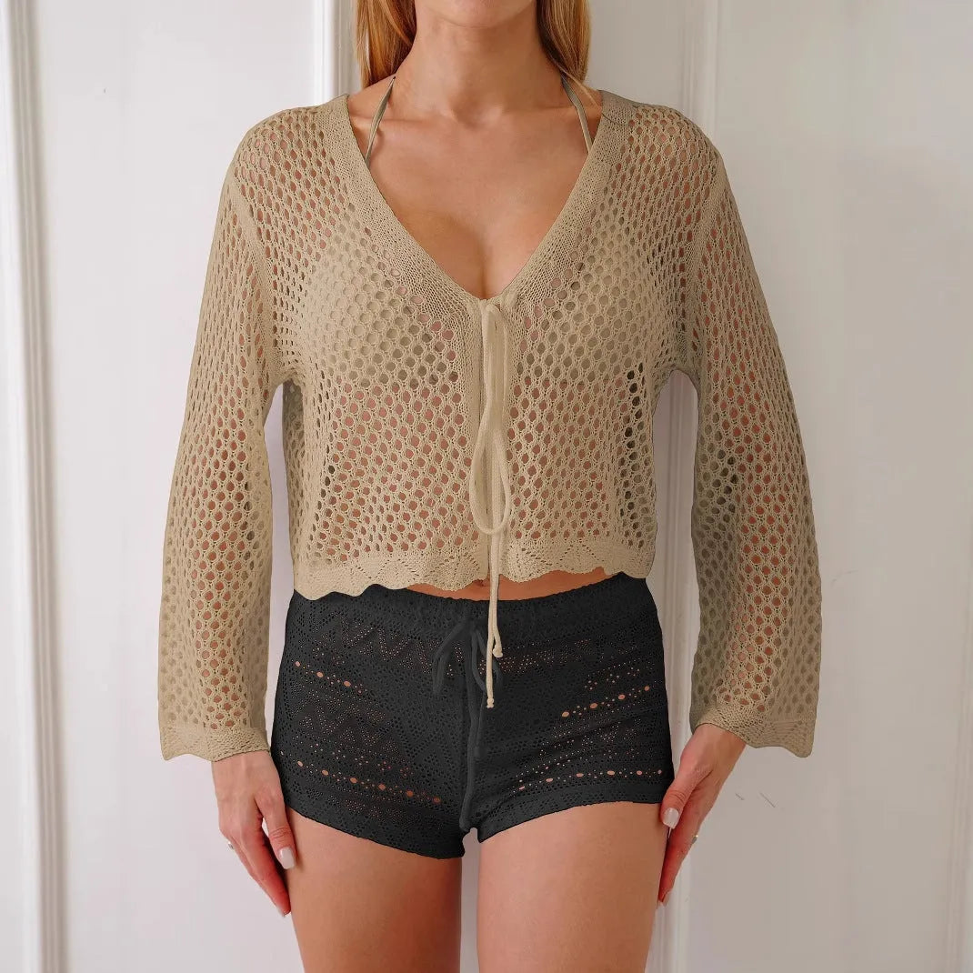 Short apricot hollow woven cardigan blouse with bell sleeves on a hanger.