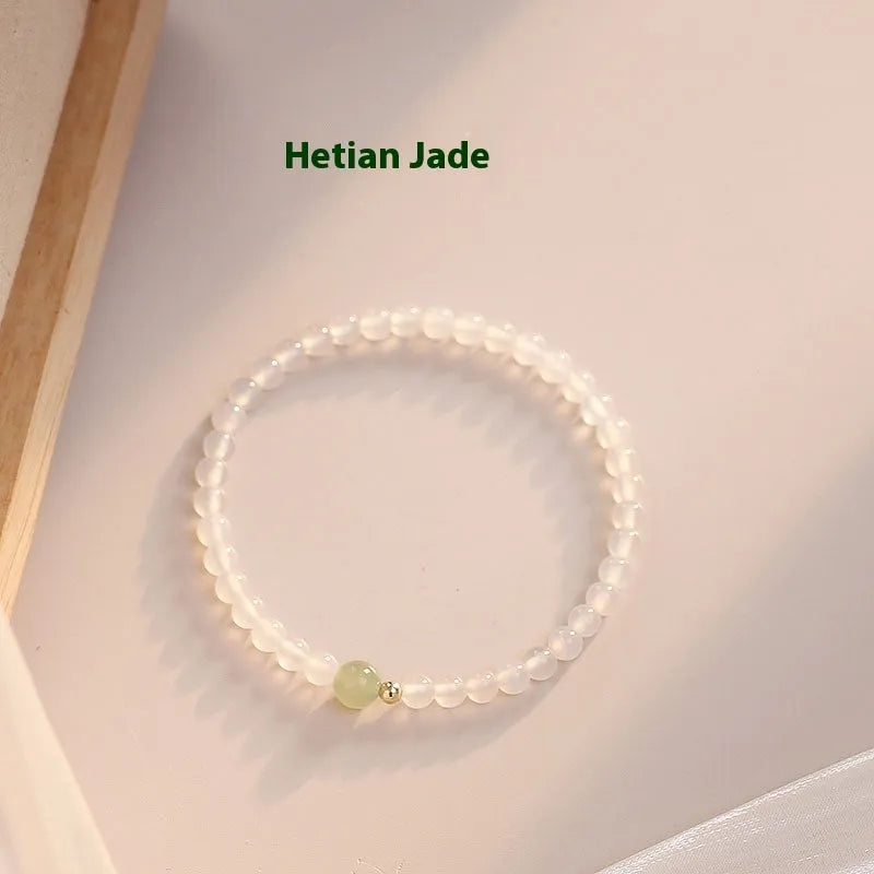 Close-up of a women's bracelet with white agate and Hetian jade beads on a 15 cm strand.