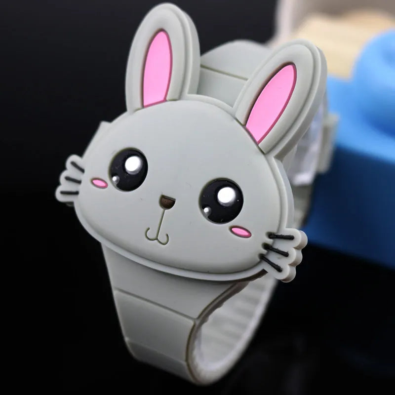 Children's electronic watch with 55mm plastic cartoon dial, silicone strap, and stainless steel pin buckle on a child's wrist