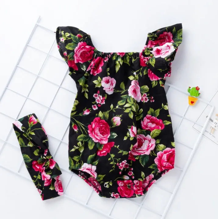 White baby girl's sleeveless cotton romper with small flying sleeves on a hanger.