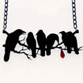 Black Gothic crow necklace with electroplated finish and cross chain on dark background