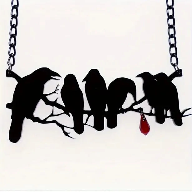 Black Gothic crow necklace with electroplated finish and cross chain on dark background