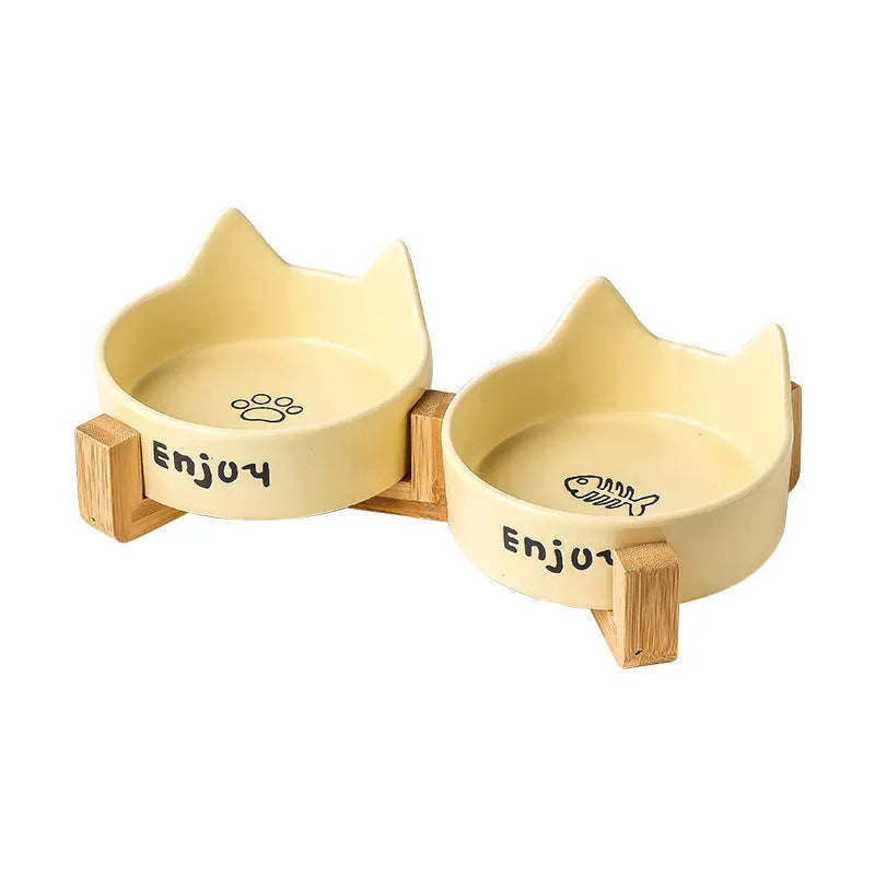 Porcelain cat bowl with cat ear and paw design on a wooden feeding frame, in pink colour.