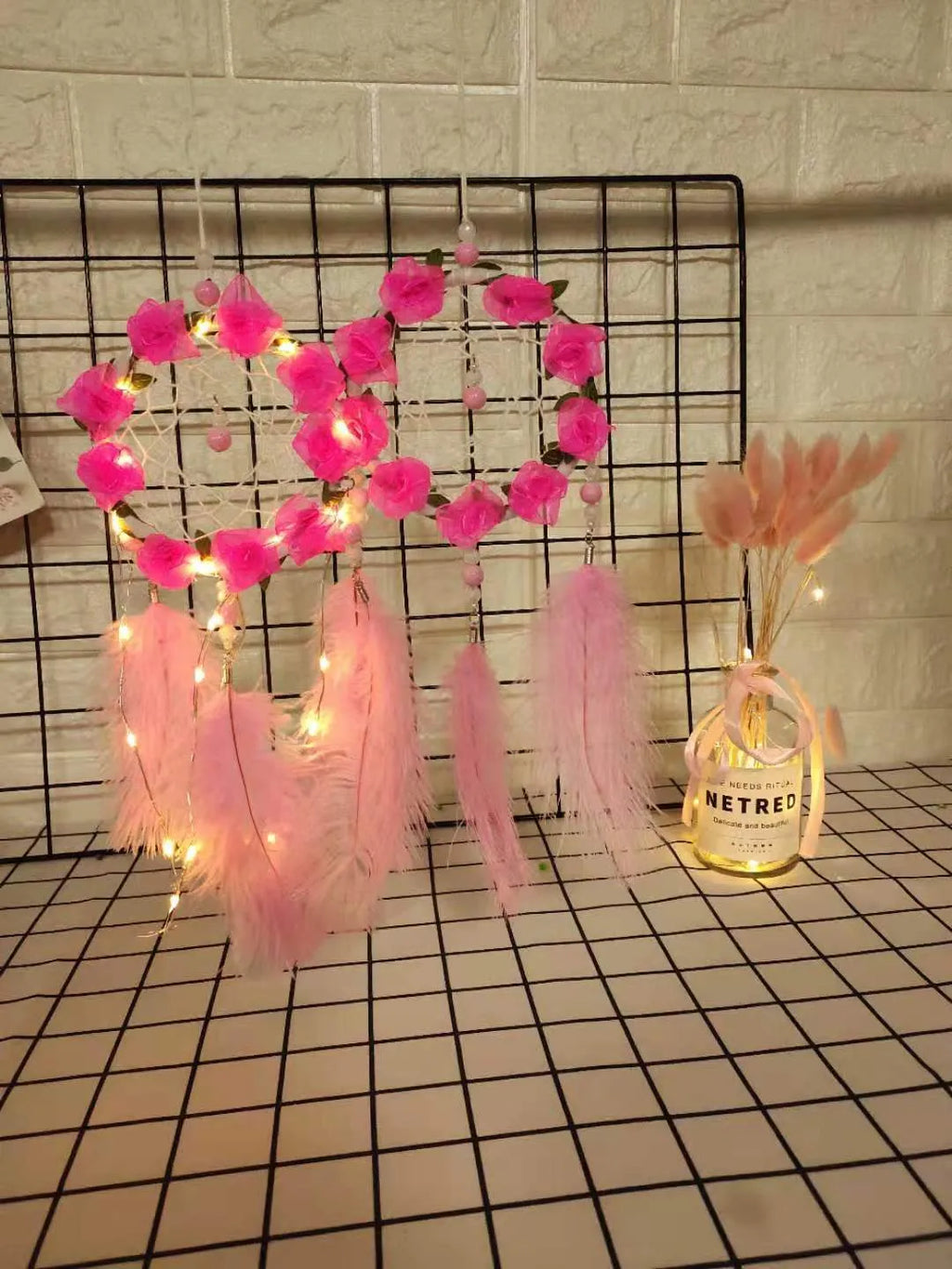 Close-up of a modern pink ostrich feather dreamcatcher wind chime wall ornament.