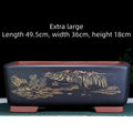 A deep blue black handmade rectangular purple clay bonsai pot on a wooden surface.
