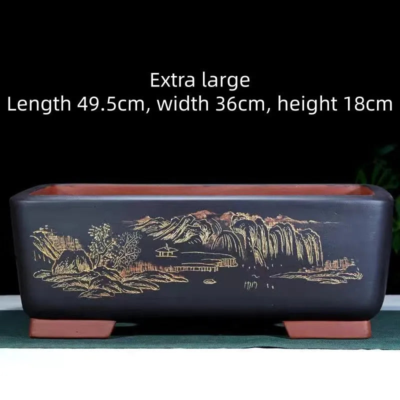 A deep blue black handmade rectangular purple clay bonsai pot on a wooden surface.