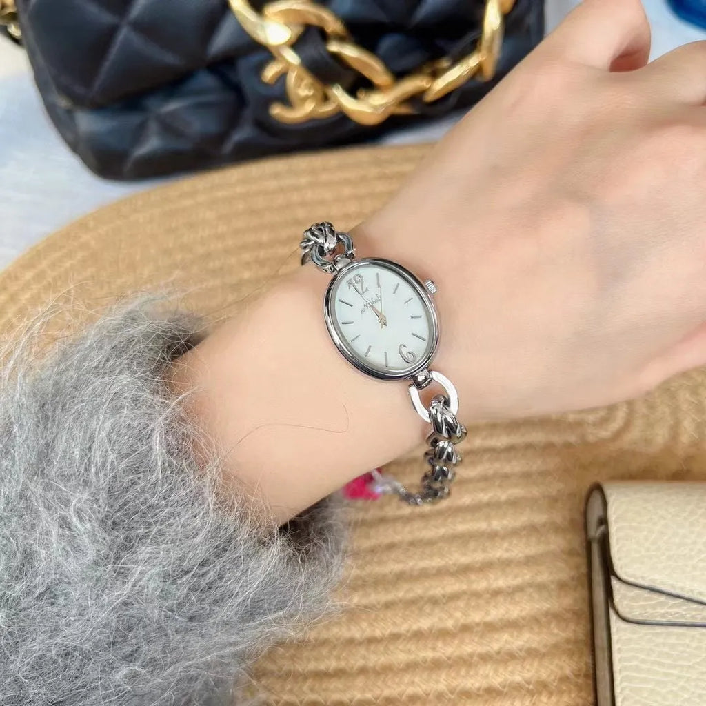 Ladies steel strap watch with oval hollow chain, silver case, white face, casual style