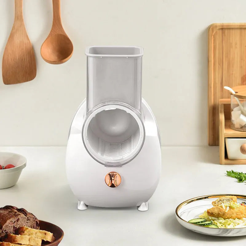 White electric vegetable slicer with suction base and interchangeable blades on kitchen counter