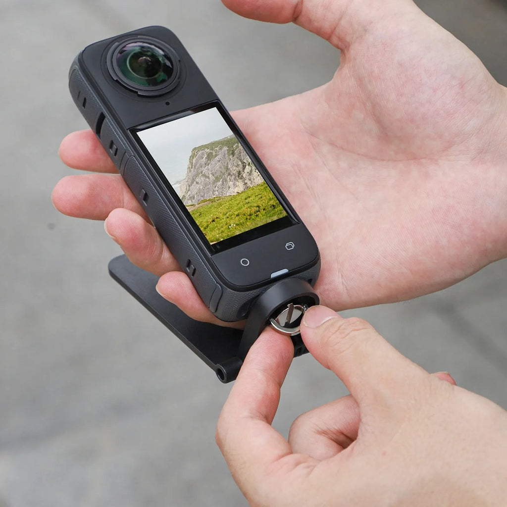Black magnetic bracket base and handle accessory for Insta360 X4 camera on a desktop