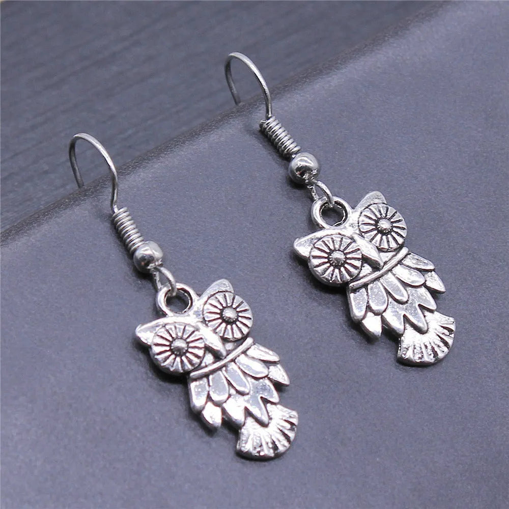 Retro minimalist handmade owl drop earrings in Antique Silver metal finish on a light background