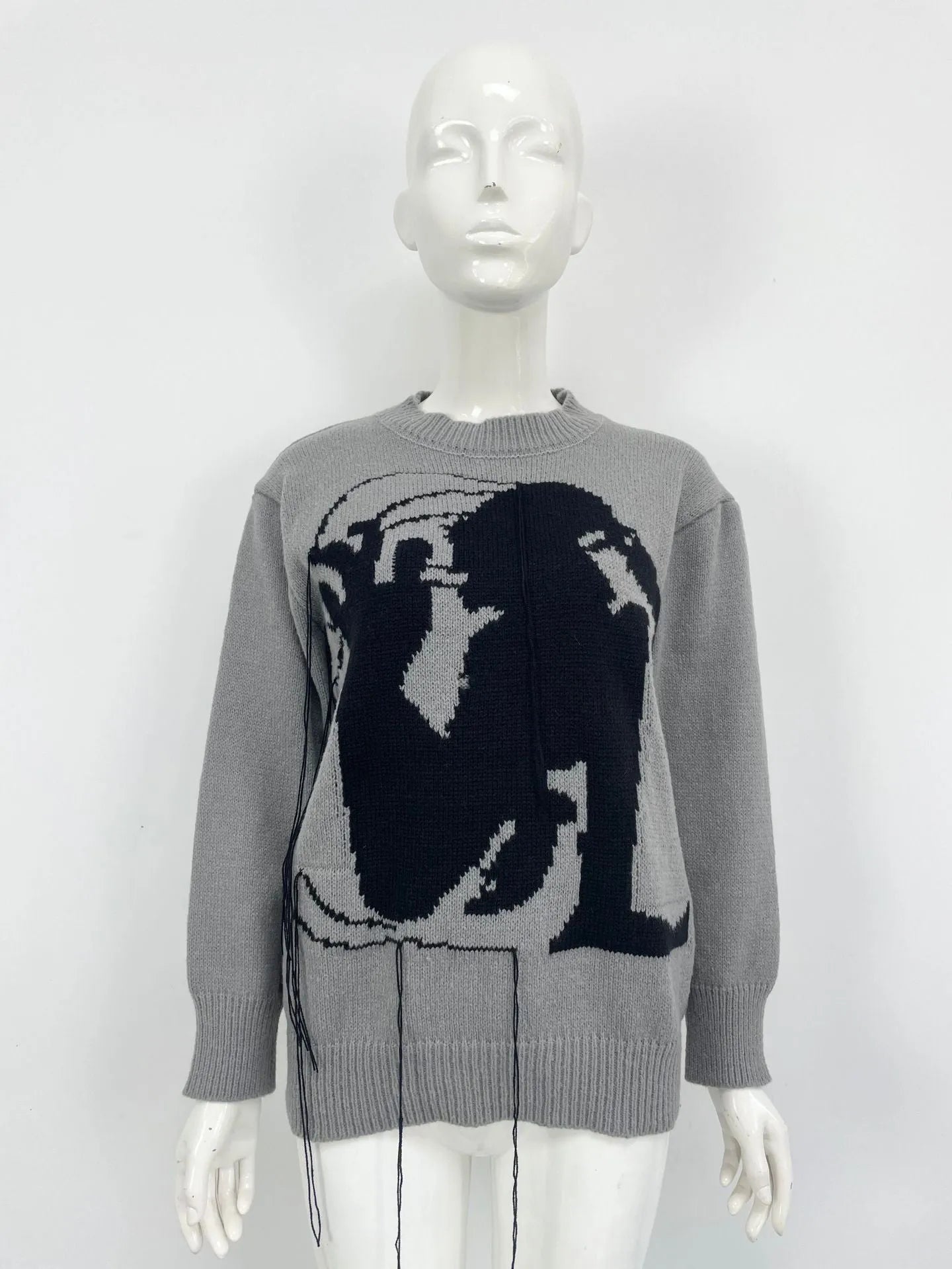 Grey loose women's alpaca wool pullover sweater with tassel detail on a hanger.