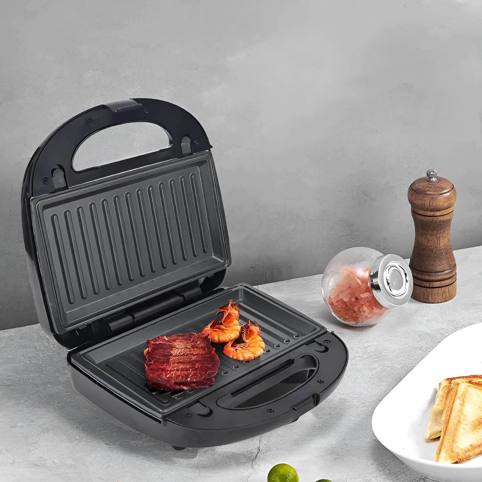 Black electric sandwich maker with double-sided heating, brushed stainless steel lid, and non-stick plates.