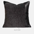 Modern grey and white plaid bed runner blanket set with round leather pillow on a bed.