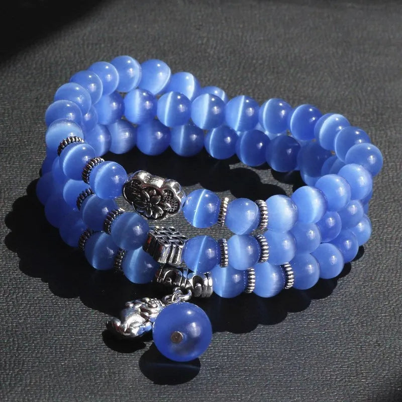 Opal cat eye bracelet with three geometric rings and lucky cat charms on adjustable 52cm cord
