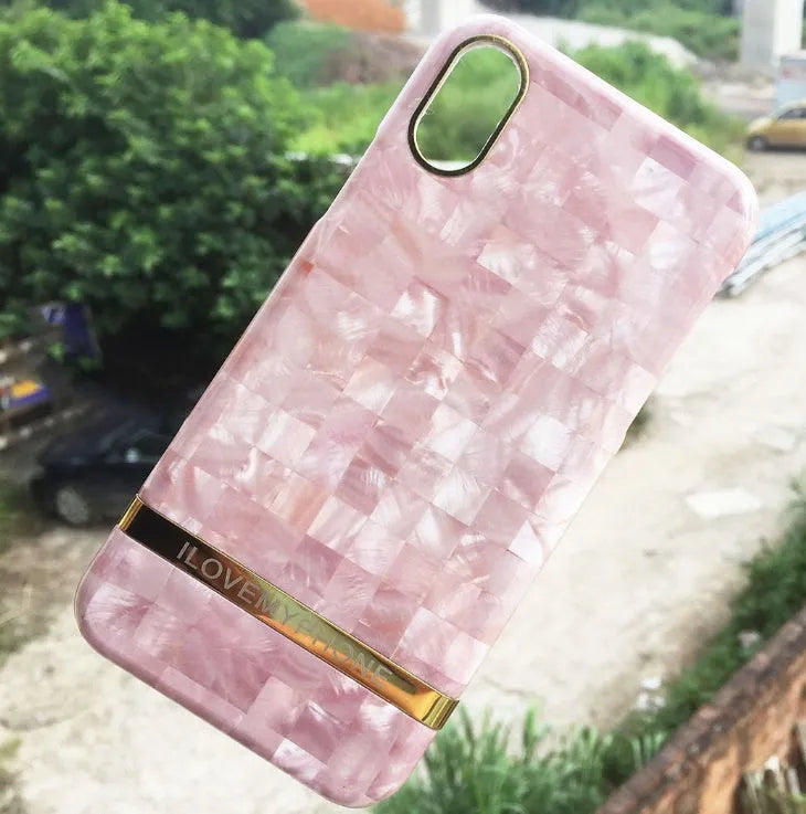 Marble pattern plastic protective case for iPhone in multiple colour options on a dark surface.