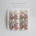 Set of children's cloth hairclips with a dovetail bow design in various colours including beige and blue flowers.