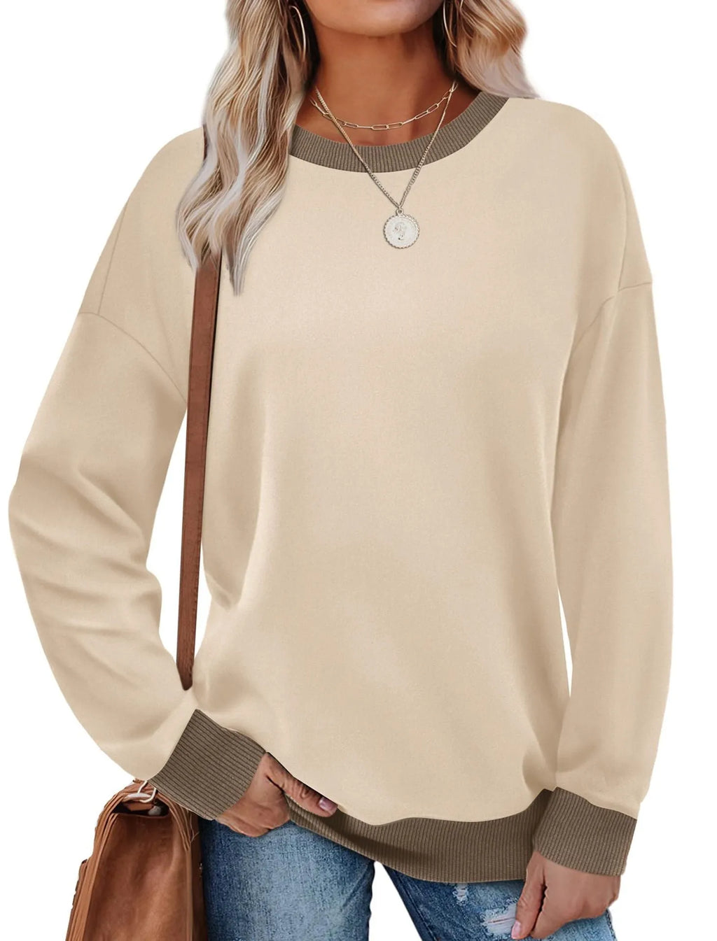 A woman wearing a loose-fitting striped long-sleeved top with a round neck in a grey colour.