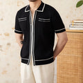 Man's slim fitting short sleeve polo shirt with a lapel collar in black, made from a lightweight knitted fabric.
