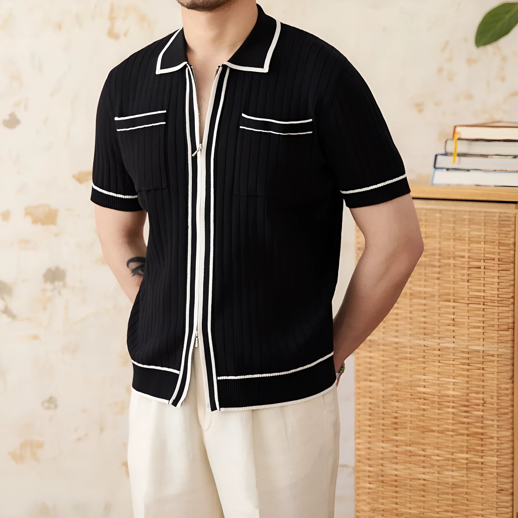 Man's slim fitting short sleeve polo shirt with a lapel collar in black, made from a lightweight knitted fabric.