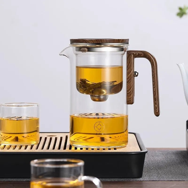 Glass teapot with wooden handle showing magnetic separation inner container and drip-free spout.
