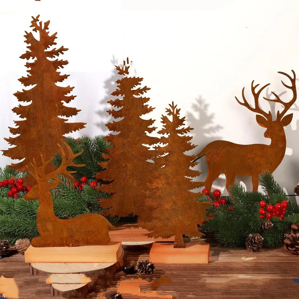 Set of three rustic iron metal Christmas tree and elk silhouette ornaments on a wooden surface.