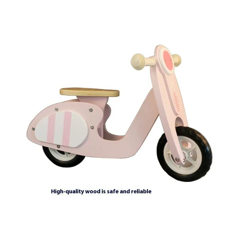 Pink wooden balance scooter for toddlers with a 10-inch non-slip deck.